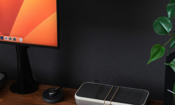 a desk with a laptop, keyboard, mouse and a monitor