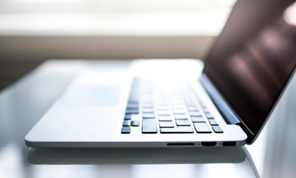 Free Elegant side view of a laptop on a glossy table with natural lighting indoors. Stock Photo