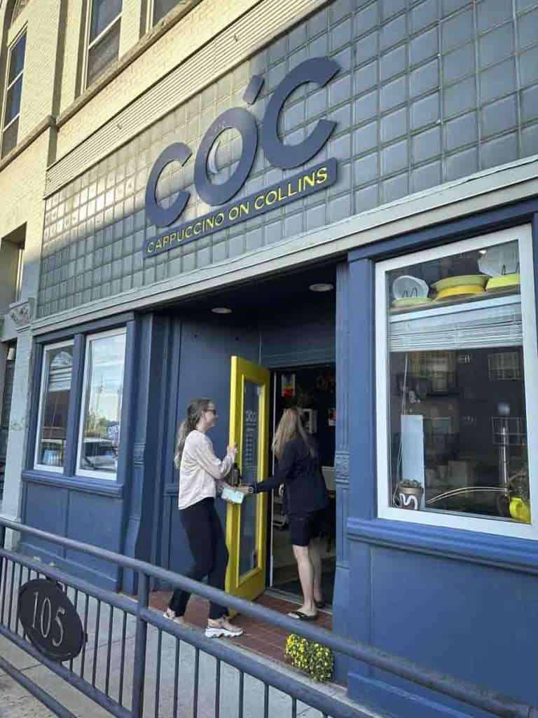 The outside of Cappuccino on Collins painted blue with large COC over the door