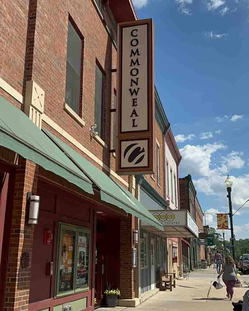 Hip Grandma Life storefront with traditional brick building, green awning, and vibrant downtown street scene.