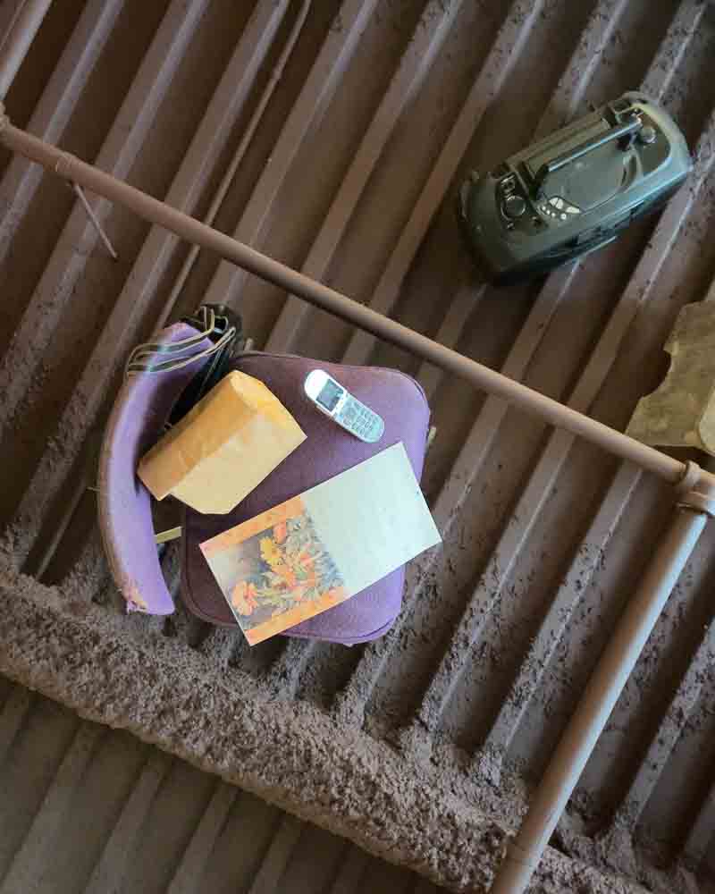 Radio, remote, and papers on a purple stool in a rustic wooden attic space.