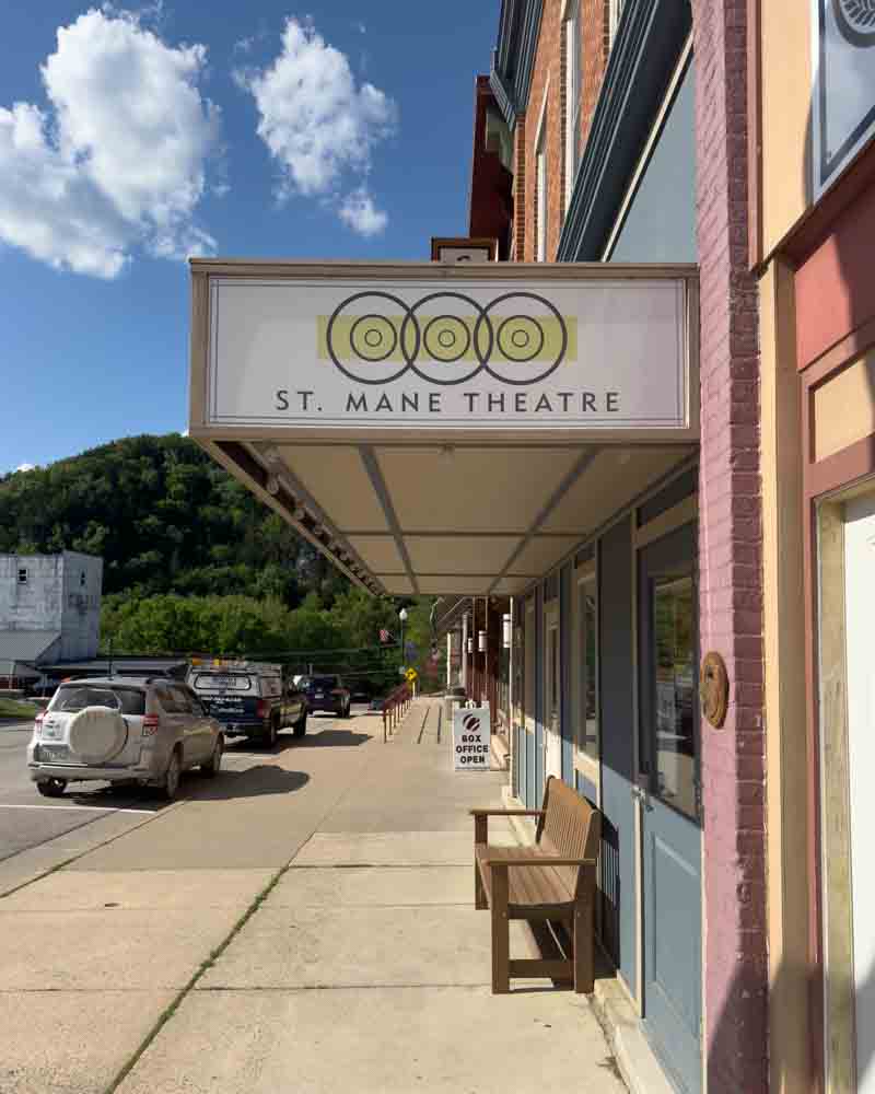 St. Mane Theatre storefront on Main Street with vintage signage and bench outside, vibrant downtown setting, perfect for local entertainment and cultural events.