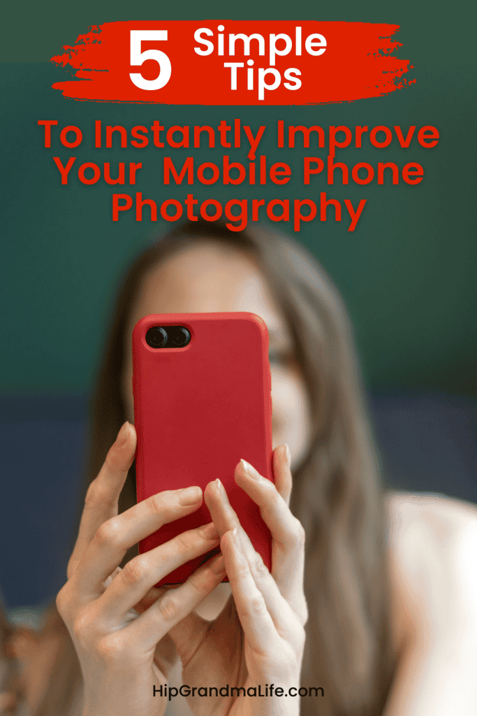 Close-up of a woman taking a photo with a red smartphone, emphasizing mobile phone photography tips for seniors, easy smartphone camera use, and enhancing photo quality for older adults.