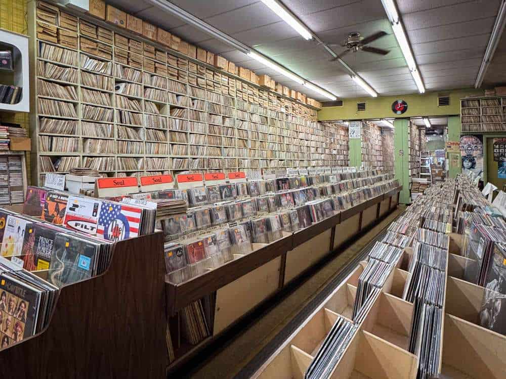 Vintage record store with extensive vinyl collection and shelving filled with albums, creating a nostalgic atmosphere for music enthusiasts.