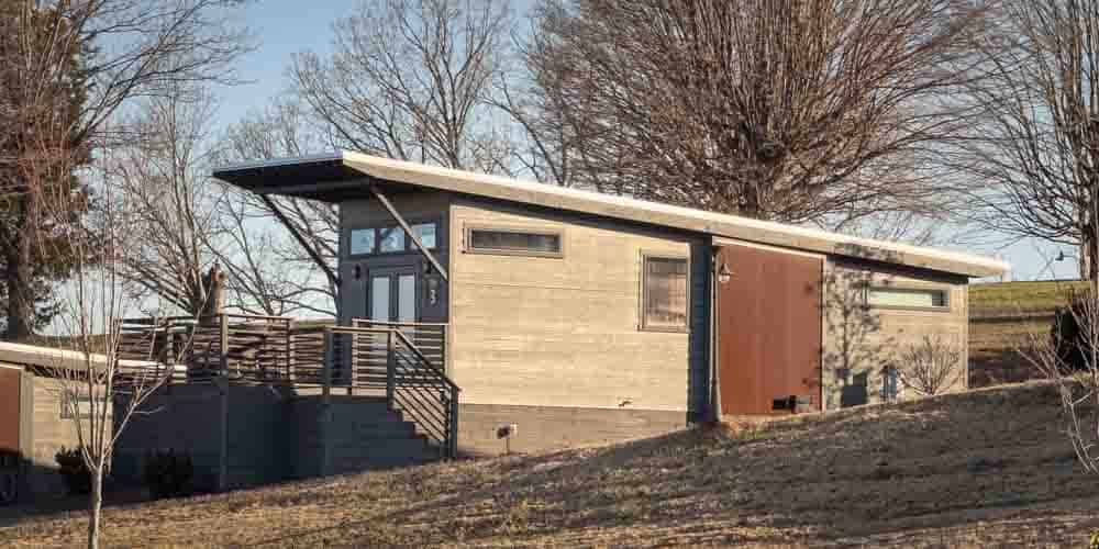Small modern tiny house on a hill with a deck and grill at The Ridge Outdoor Resort