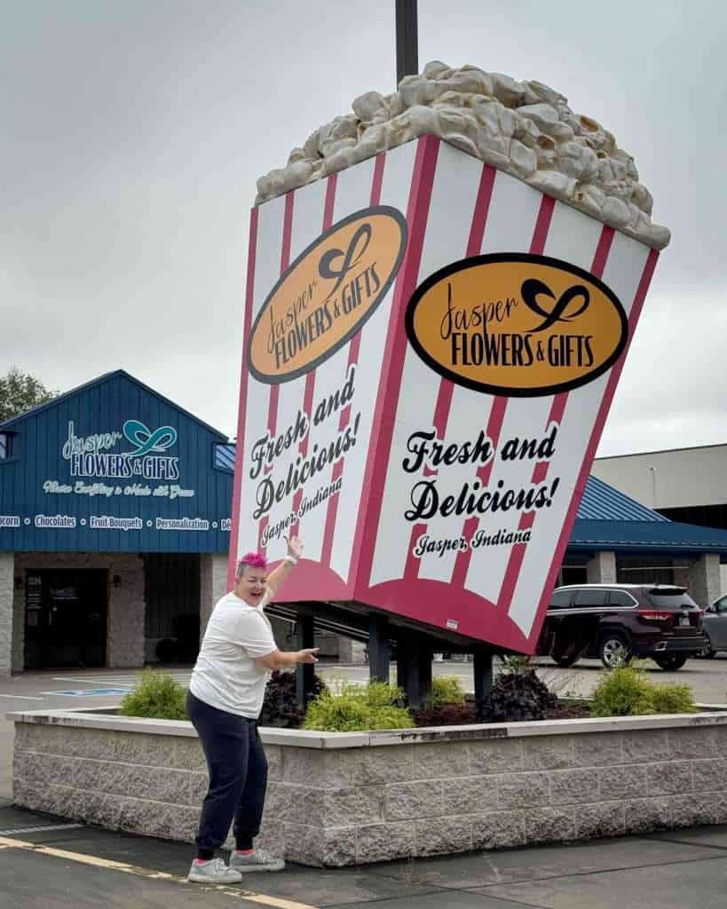 Traveler posing beside the giant popcorn box in Jasper, Indiana, one of the most recognizable roadside attractions Indiana has to offer.