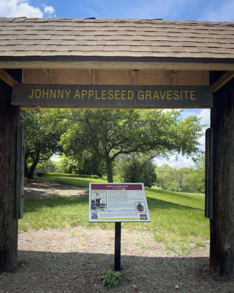 Entrance sign to Johnny Appleseed’s gravesite in Fort Wayne, Indiana, surrounded by trees and grass