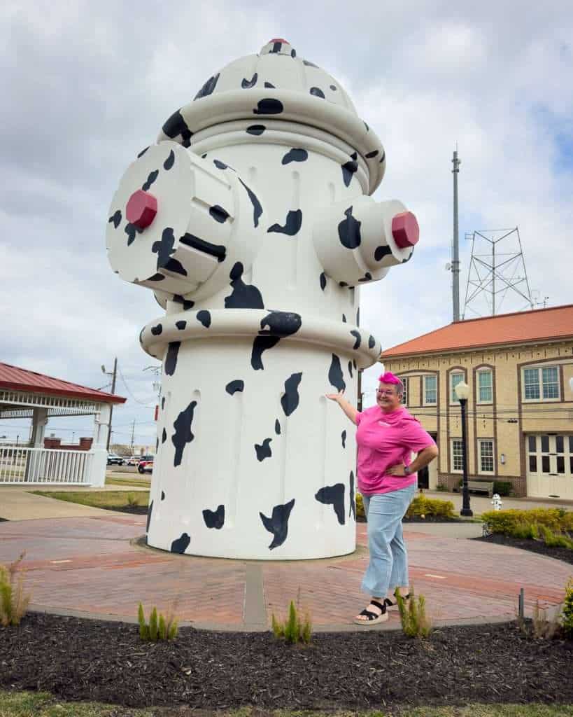 Pink-haired Hip Grandma posing with world’s largest fire hydrant in Beaumont Texas
