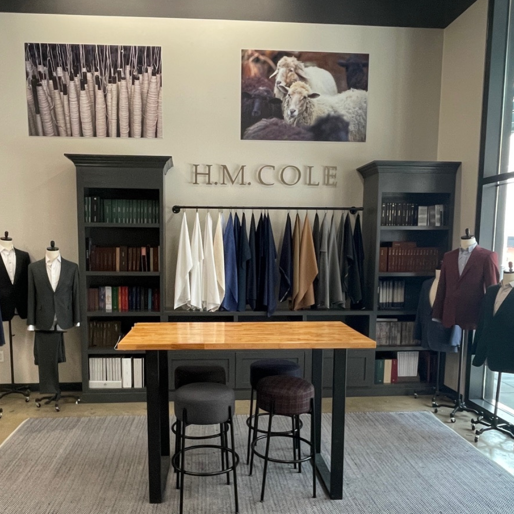 Modern clothing store interior with mannequins and fabric samples.