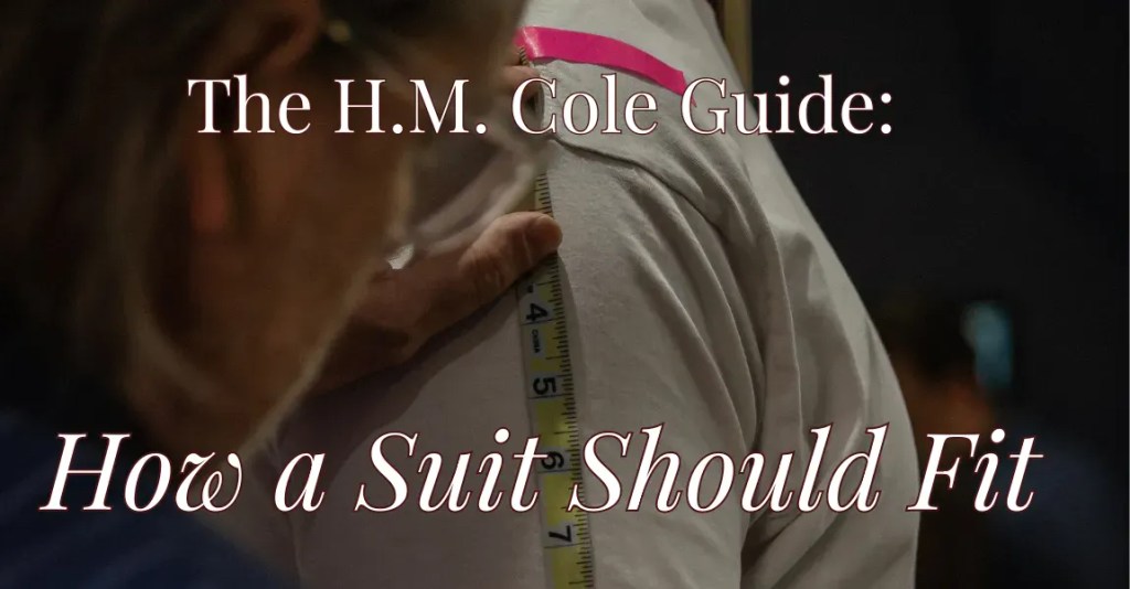 Tailor measuring a suit jacket for perfect fit at H.M. Cole.