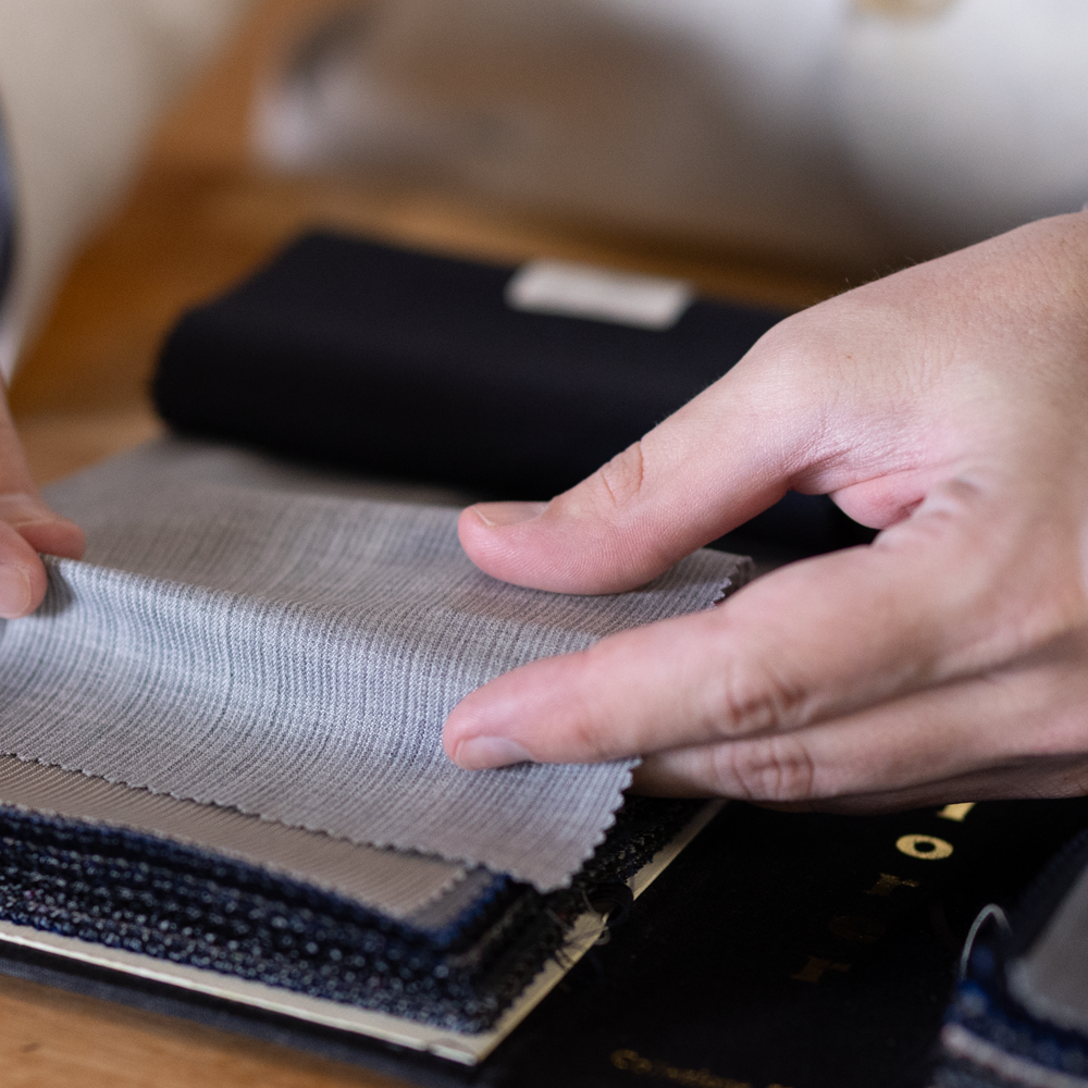 Hand selecting fabric swatches for custom upholstery at H.M. Cole.