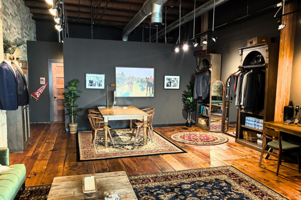 Stylish retail space with clothing racks, a central table, and artwork on dark walls.