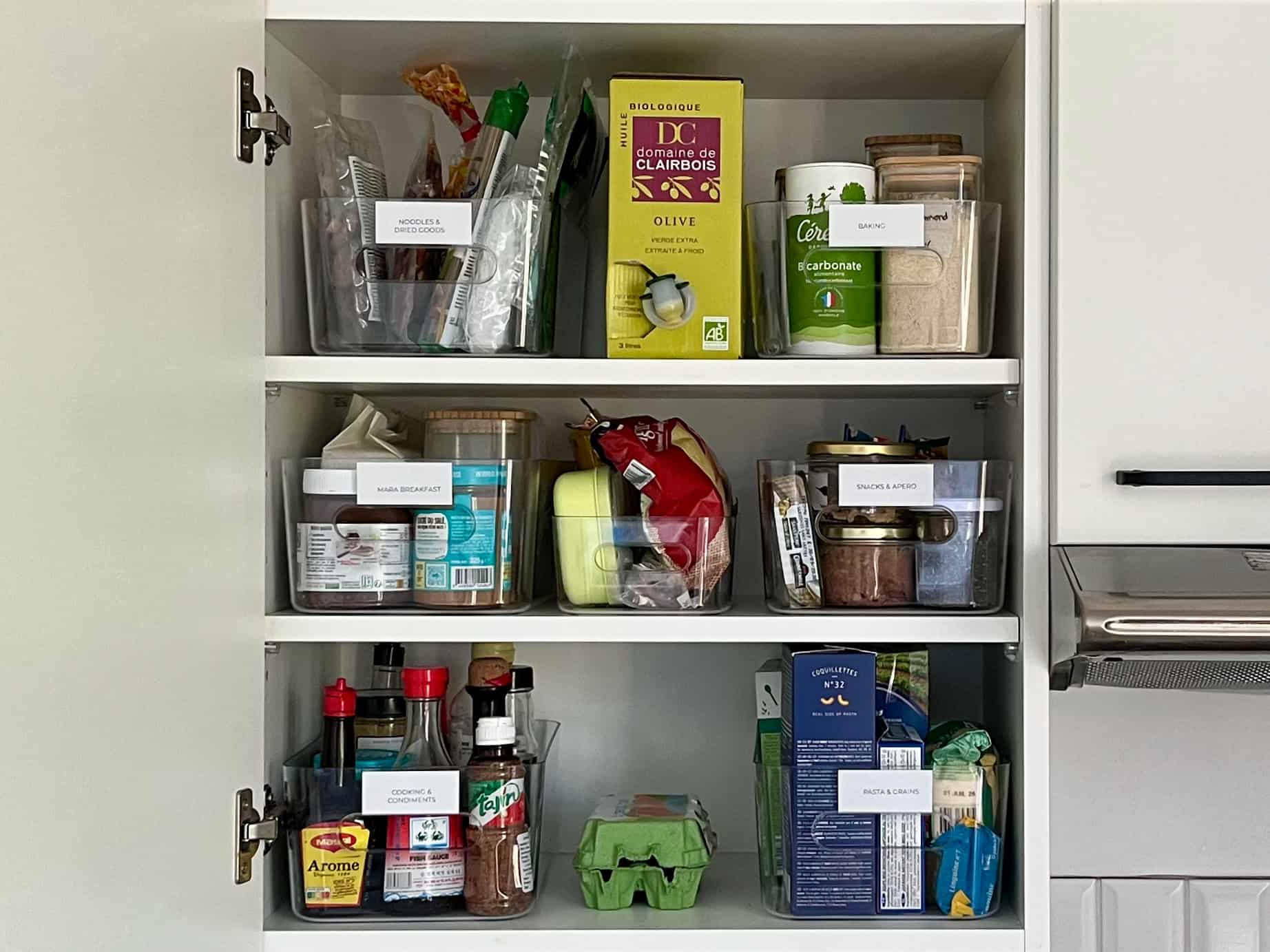 After: Well organized pantry cabinet with baskets and plant above