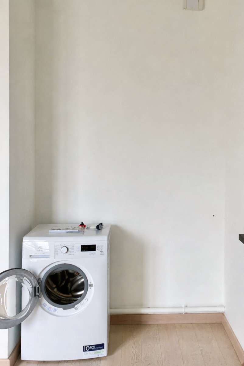 Blank nook, white wall with a washing machine