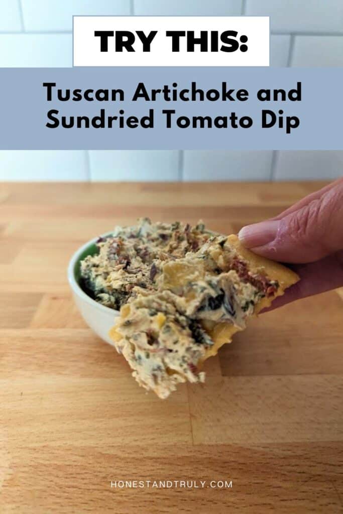 Image shows a bite of Tuscan artichoke and sundried tomato dip.