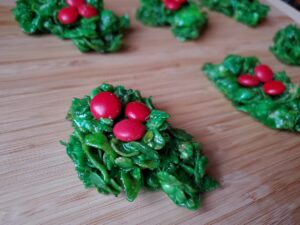 Classic holly wreath cookies on a wooden board.