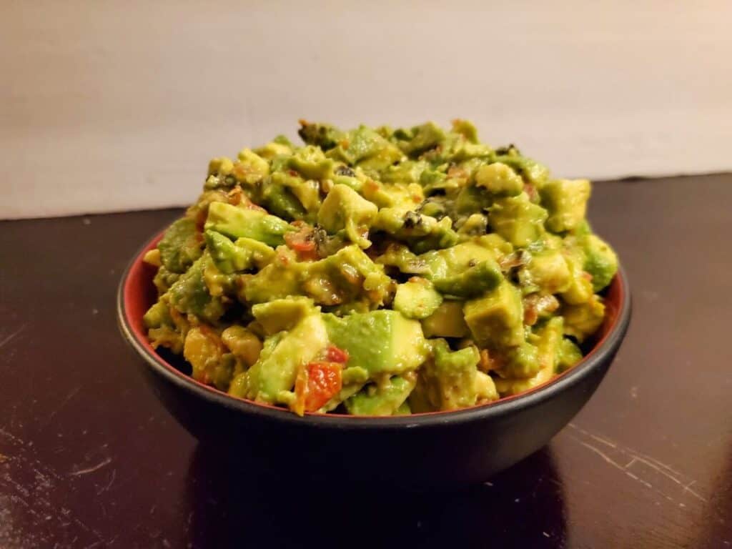 Image shows chunky guacamole served in a bowl.
