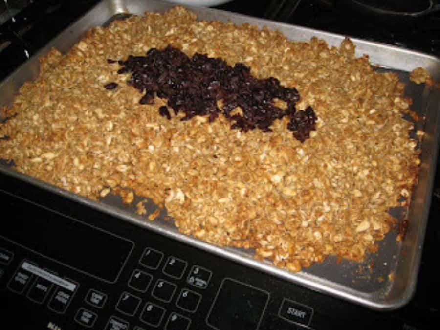 Image shows baked homemade granola with dried cherries on top.