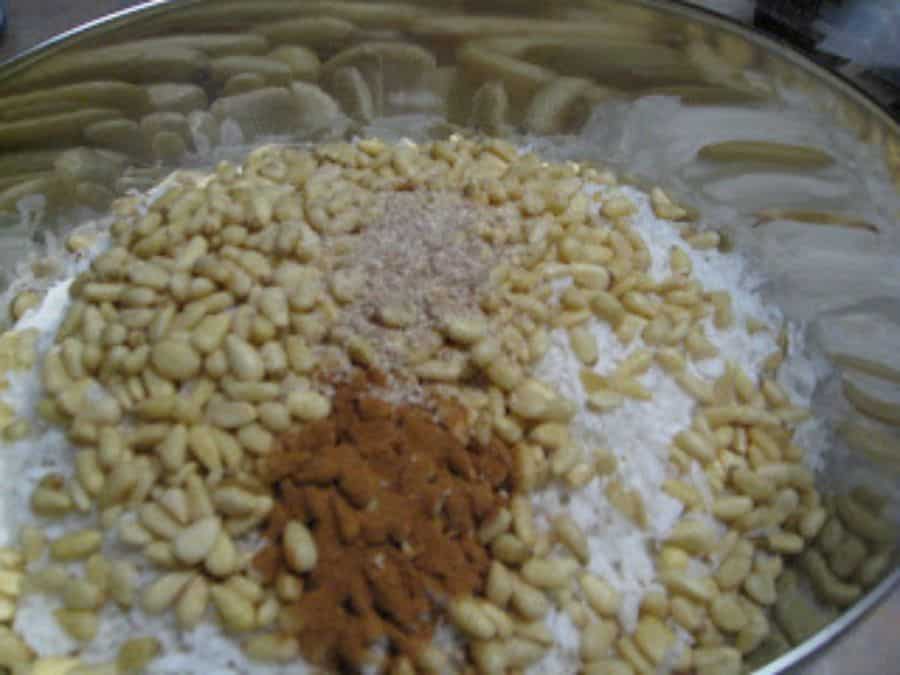 Image shows dry ingredients of homemade granola mixed together in a bowl.