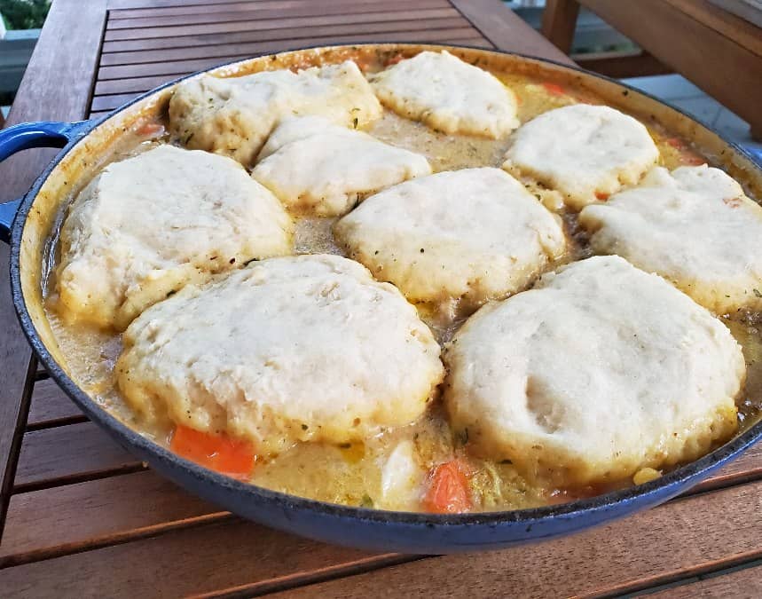 Pot of chicken stew on a wooden table