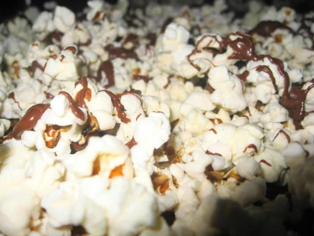 Image shows popcorn drizzeled with chocolate.