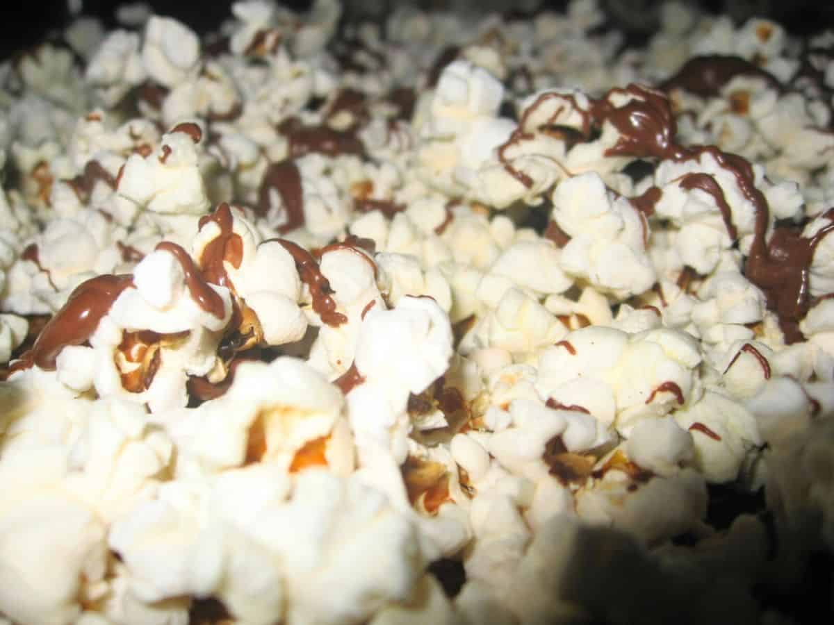 Image shows popcorn drizzeled with chocolate.