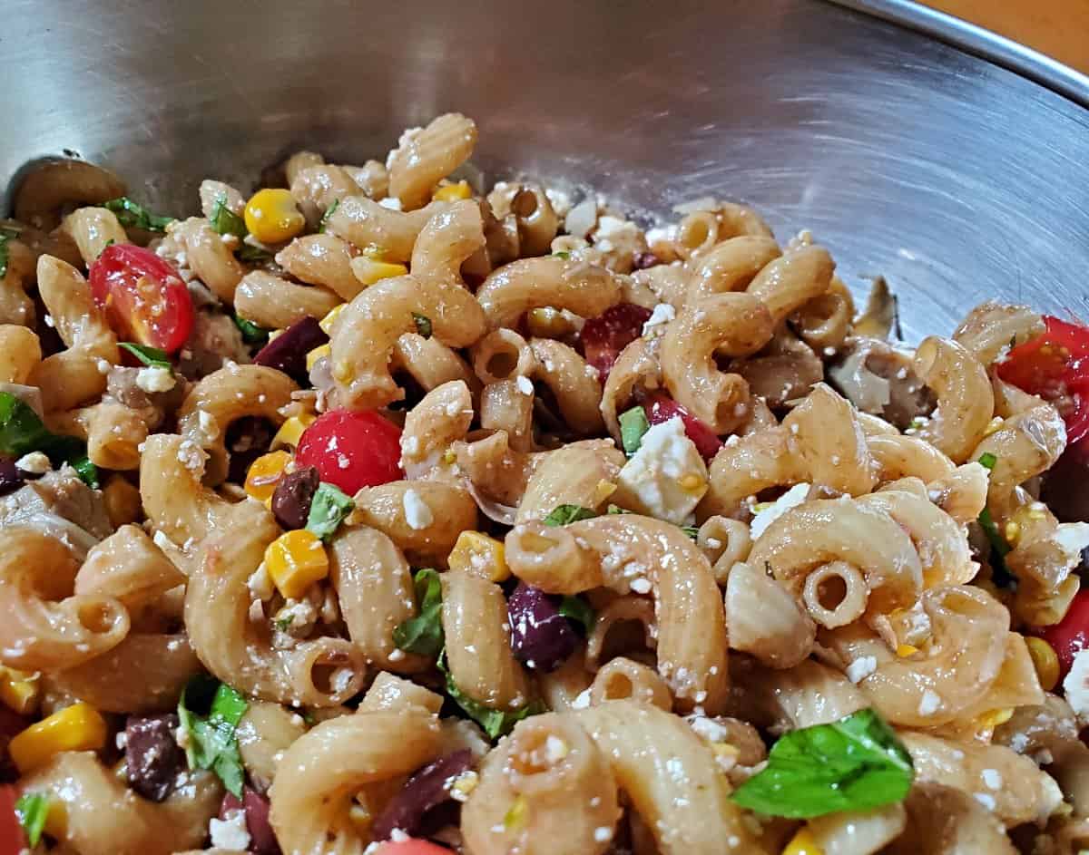 Image shows a closeup of a Summer Pasta Salad with Mediterranean flavors.