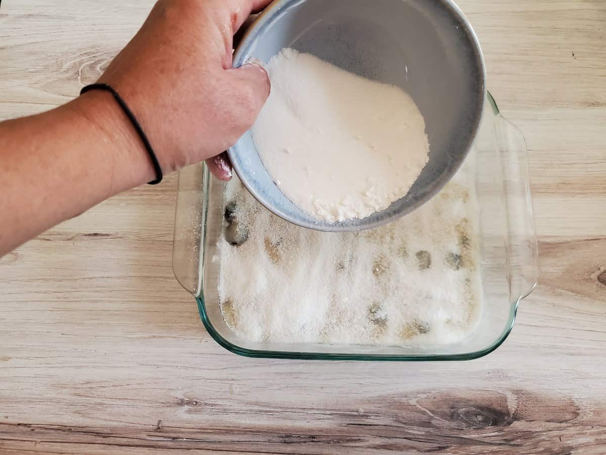 Sprinkling sugar over cake batter.