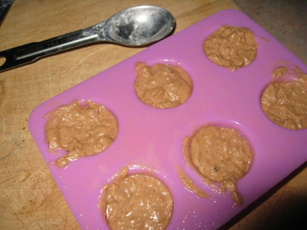 Image shows cookie batter in a pink itty bitty baking kit and a measuring spoon on the side.