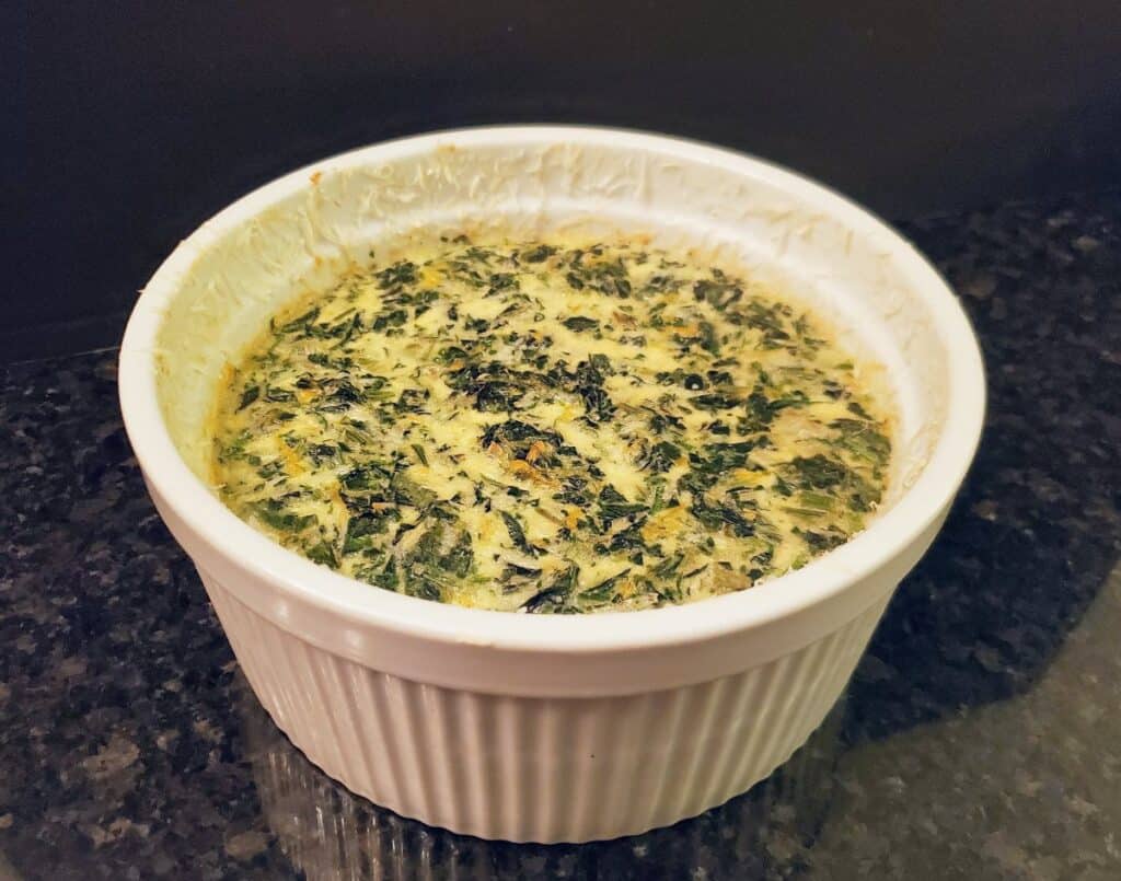 Whole baked spinach souffle in its dish.