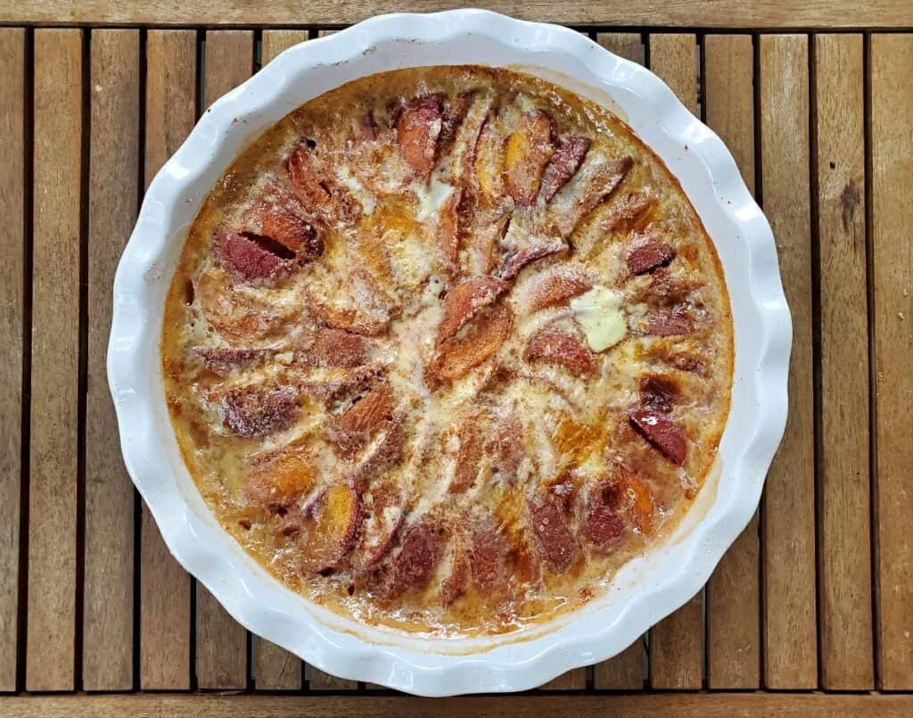 Overhead shot of a baked peach kuchen in a pie pan.