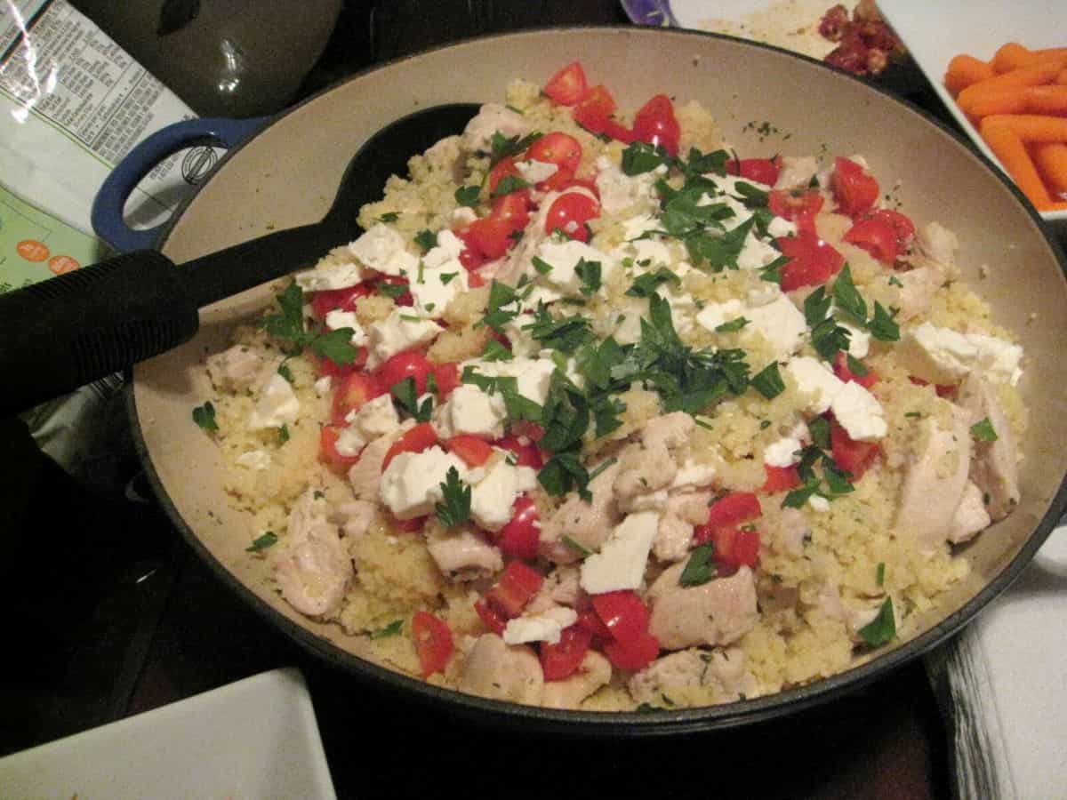 Image shows Mediterranean couscous in a pot with a ladle.