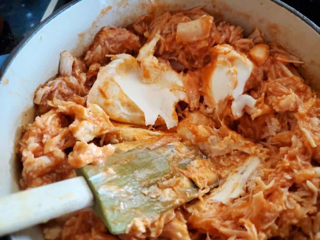 Image shows cream cheese and ranch dressing added to chicken with hot sauce.
