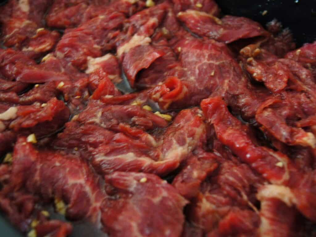 Image shows beef added to the marinade.