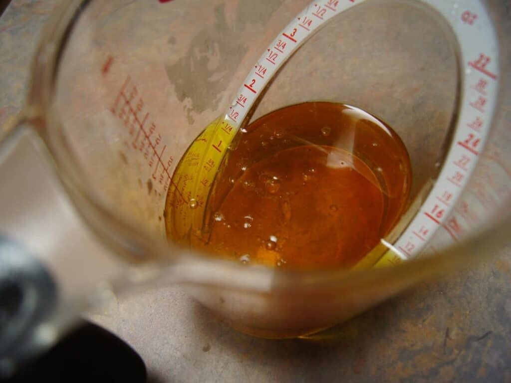 Image shows liquid ingredients for chocolate cinnamon cupcakes in a liquid measuring cup.