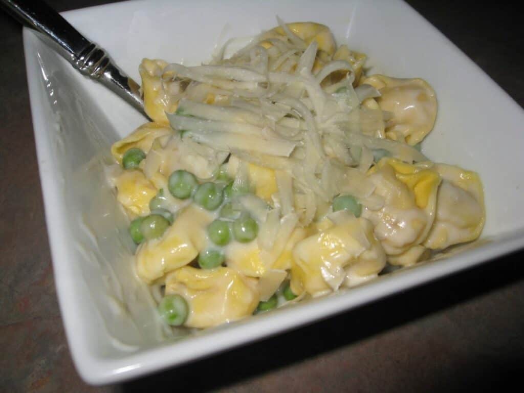 Image shows spring pea cream sauce with pasta in a bowl.