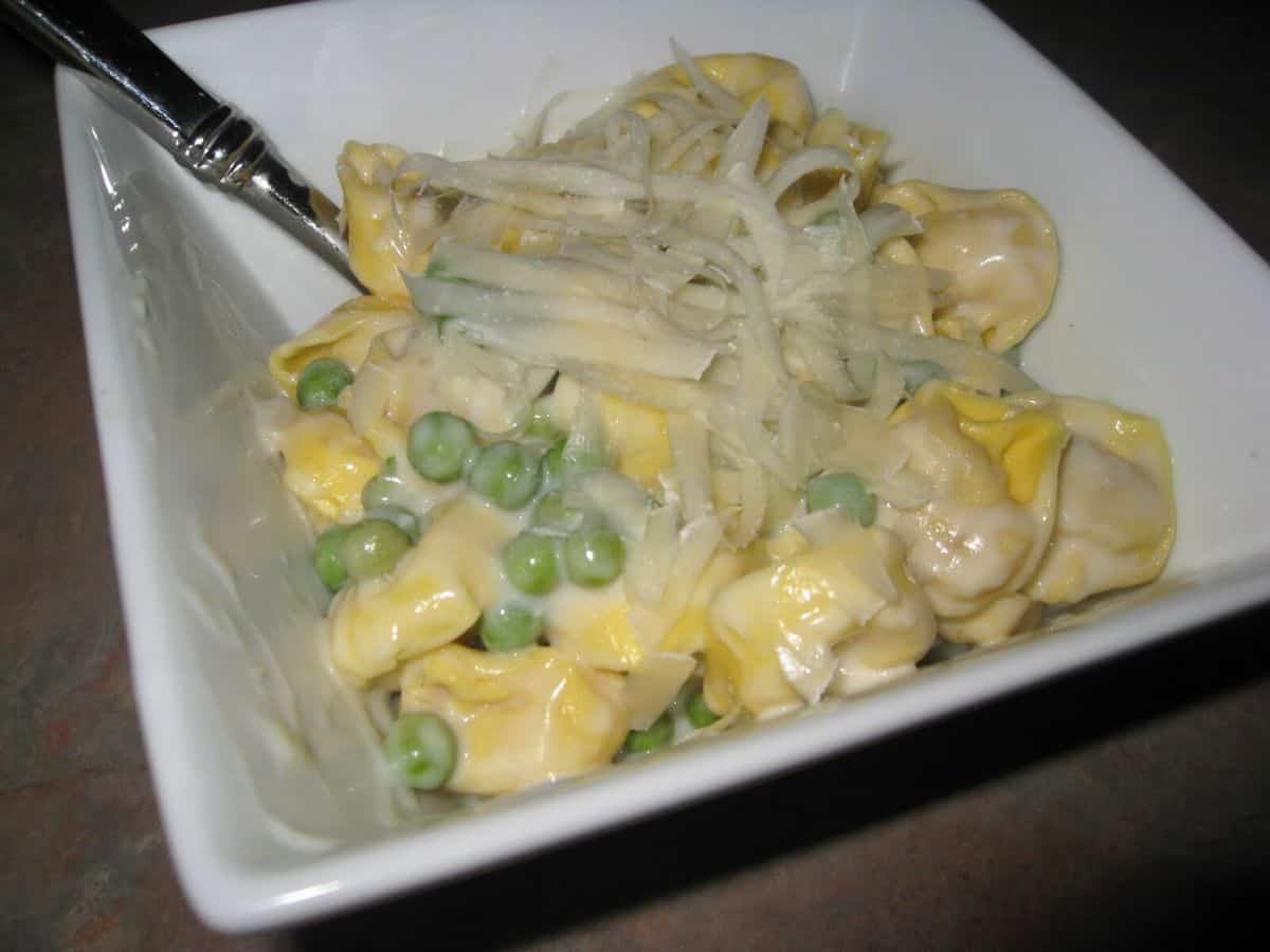 Image shows spring pea cream sauce with pasta in a bowl.