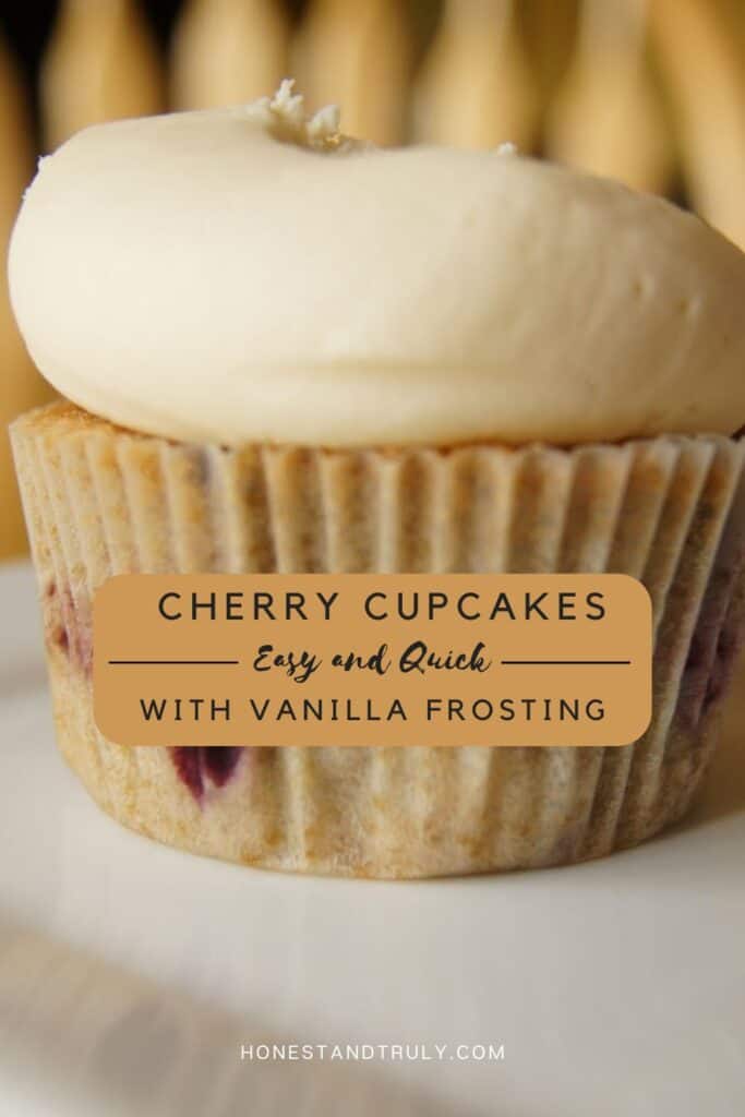 Image shows close-up picture of cherry cupcakes with vanilla frosting on a serving plate.