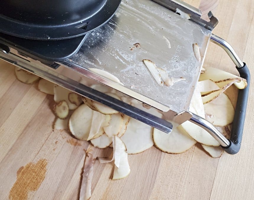 Mandolin with thinly sliced potatoes