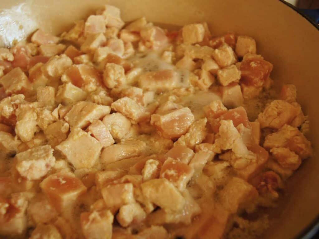 Image shows bite-sized chicken in a pan.