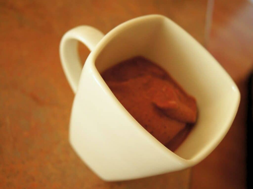 Image shows chocolate cherry smoothie in a cup.