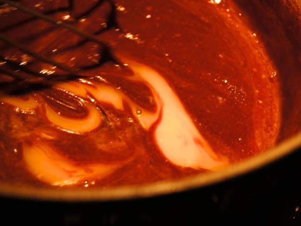 Image shows eggs added to the chocolate and butter mixture.