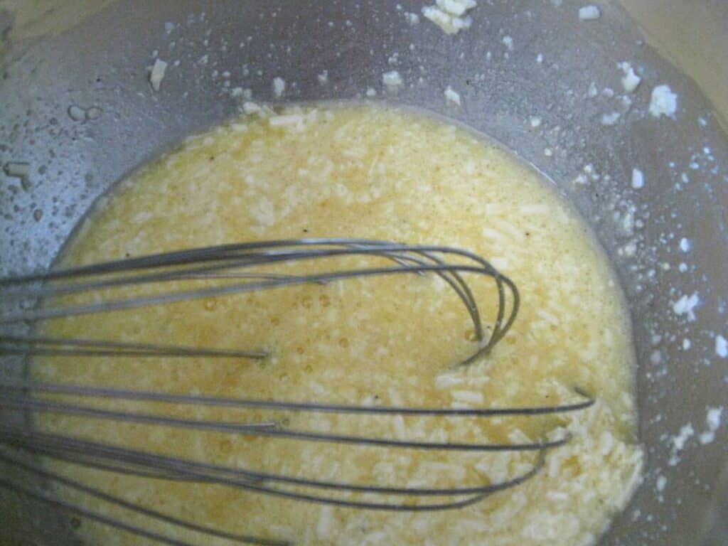 Image shows egg and cheese in a bowl.