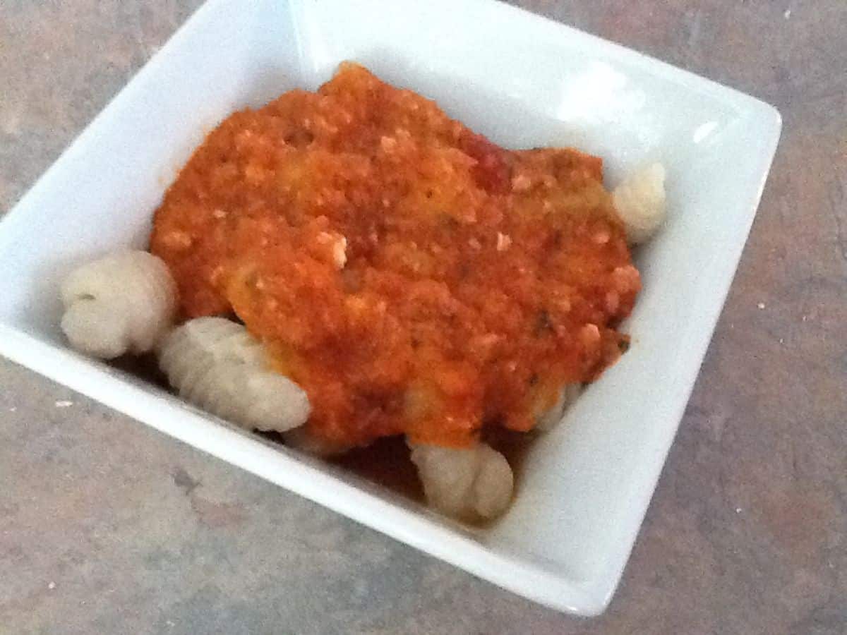Image shows homemade orecchiette with pasta sauce in a bowl.