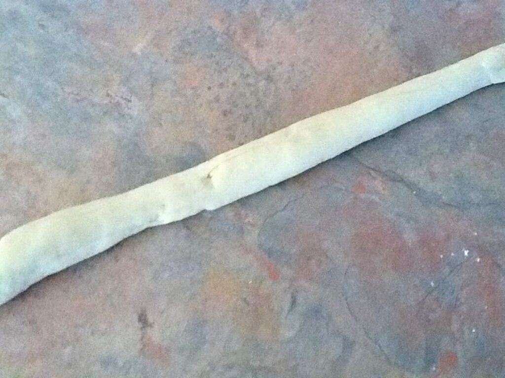 Image shows rolling pasta dough to make orecchiette.