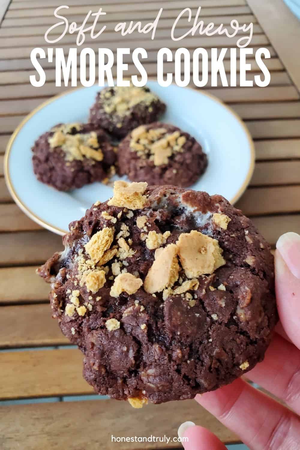 Smores Cookie held in a hand over a table with other cookies