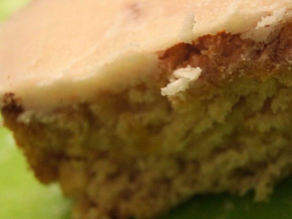 Image shows another close-up picture of peach cake with frosting.