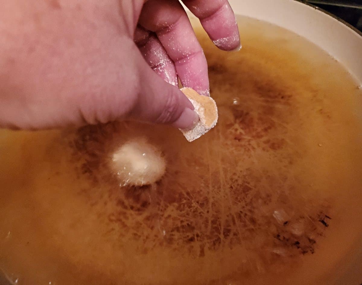 Dropping pumpkin donut holes into hot oil to cook.