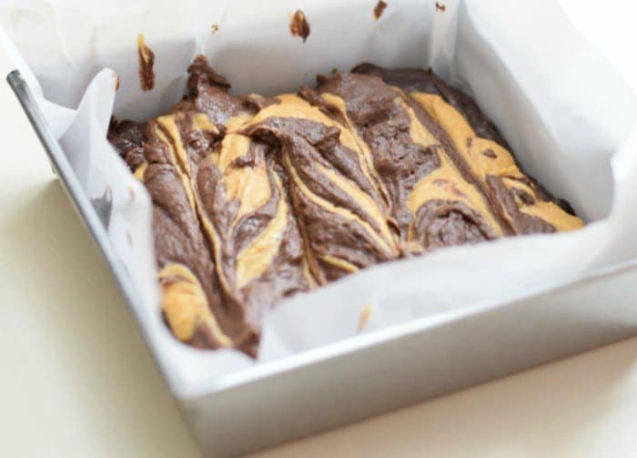 Use spatula to swirl pumpkin brownie batter