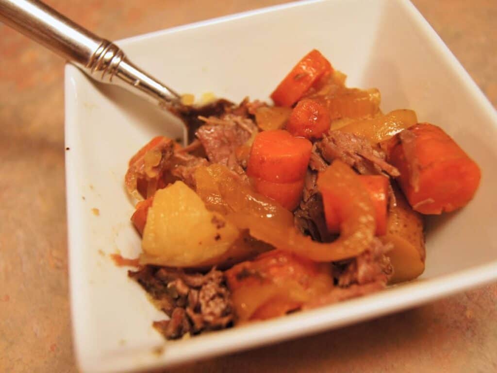 Image shows pot roast in a bowl.